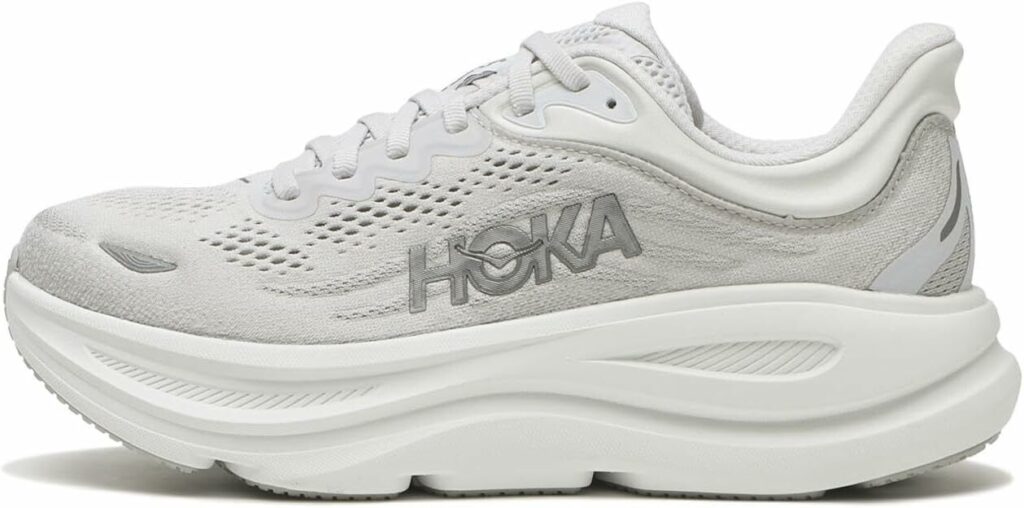 A pair of HOKA Bondi 9 sneakers in a well-lit studio setting, showcasing the robust cushioning technology. The foreground features the shoes in a high-angle view, with a focus on the thick, plush midsole that extends from the heel to the toe. The middle ground shows a cross-section of the midsole, revealing the intricate shock-absorbing foam structure. The background is a clean, minimalist setting with soft, diffused lighting, highlighting the sleek design and material textures of the shoes. The overall mood is one of premium quality, advanced comfort, and technical innovation.