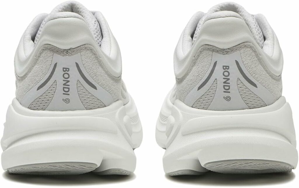 A well-lit, high-resolution image of the HOKA Bondi 9 road running shoe in a neutral gray colorway. The shoe is depicted from a side profile, showcasing its thick, plush midsole and streamlined upper design. The foreground features a close-up view of the shoe's durable rubber outsole, highlighting its grippy tread pattern. The middle ground showcases the shoe's maximal cushioning system, with the midsole appearing lightweight and responsive. The background depicts a sleek, minimalist environment, such as a clean white or gray studio setting, allowing the shoe's design to be the focal point. The lighting should be soft and diffused, creating a sense of clarity and detail. The overall mood is one of performance, quality, and technical innovation.